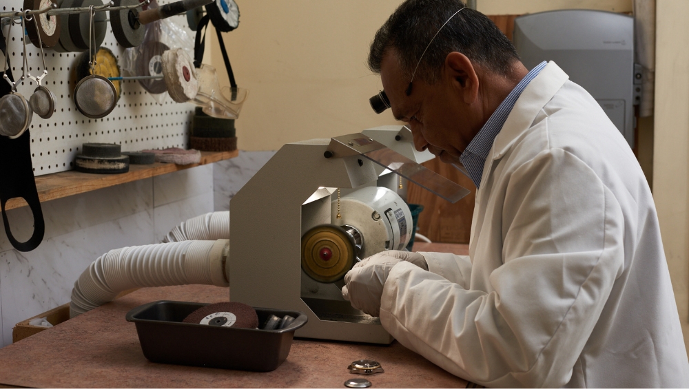 Watch repair technician polishing a timepiece