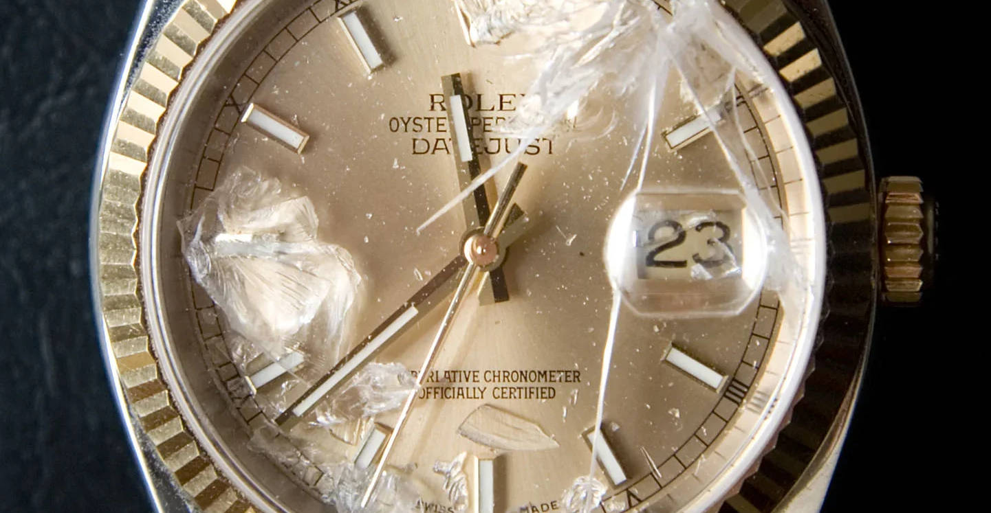 Broken vintage Rolex watch crystal requiring professional replacement