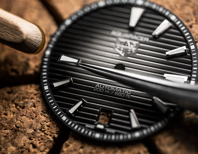 Close view of a black Tag Heuer Aquaracer-style dial from the legacy Atlanta repair page
