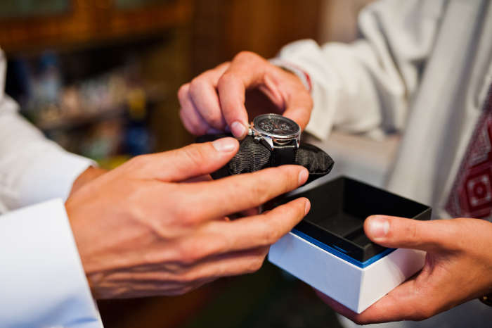 Customer and specialist examining a watch during an in-person service consultation