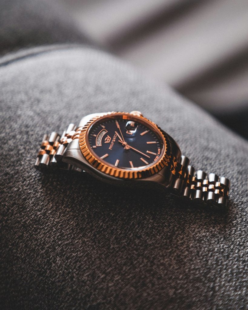 Two-tone luxury watch resting on textured dark fabric